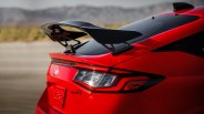 Rear view of a red Honda Civic Type R with a prominent black rear spoiler and taillight details.