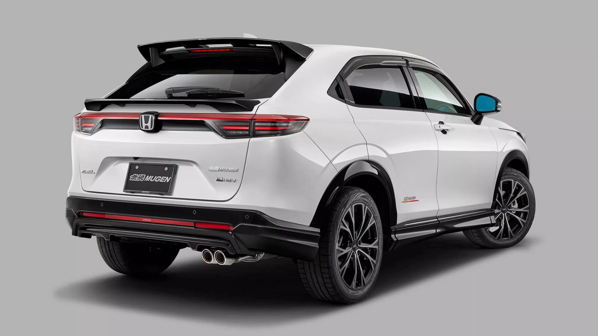 White Honda Vezel hybrid SUV with Mugen body kit and black accents shown from rear side on gray background.