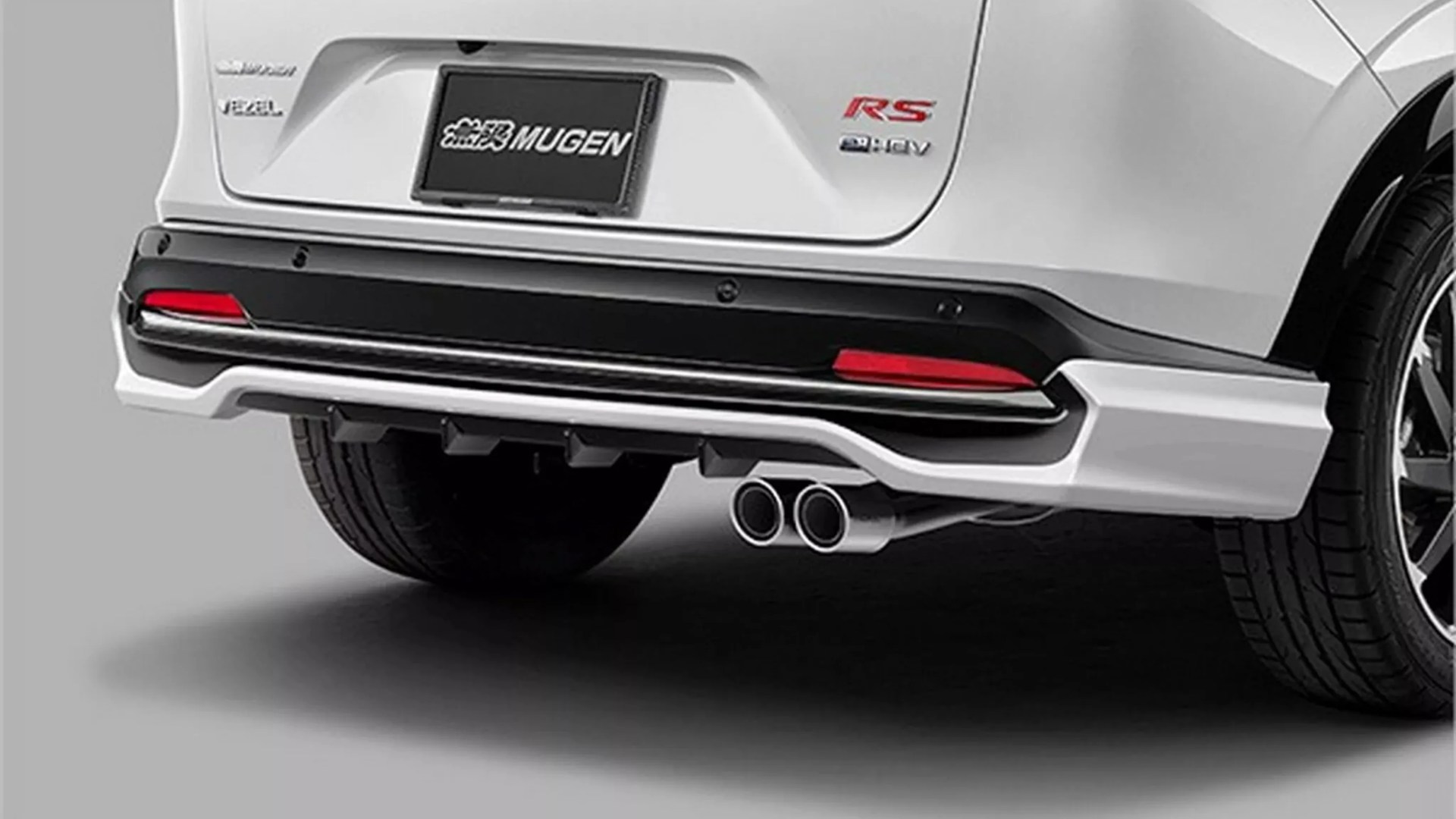 Rear view of a white Honda Vezel RS e:HEV with dual exhaust pipes and Mugen license plate.