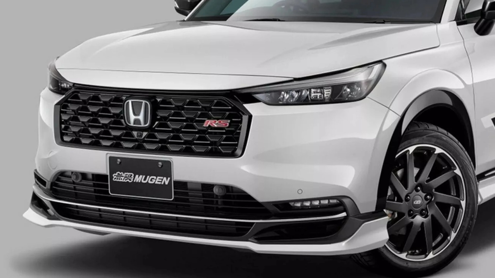 Front view of a white Honda car with black honeycomb grille, RS badge, Mugen license plate, and black alloy wheels.