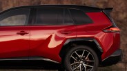 Red and black SUV rear side with tinted windows, angular body design, and black alloy wheel with Toyota logo.