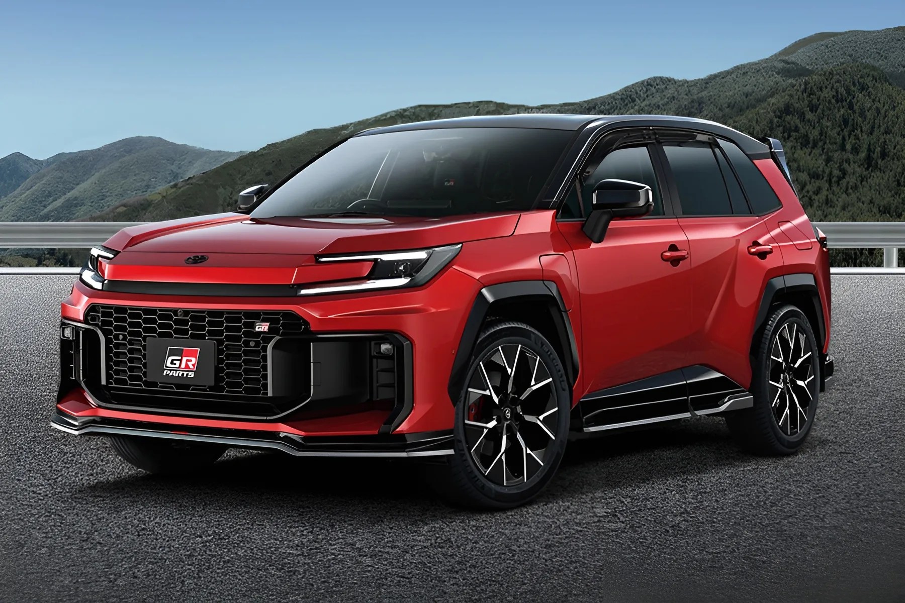 Red compact SUV with black roof, sporty front grille, and black alloy wheels parked on asphalt with mountains in background.