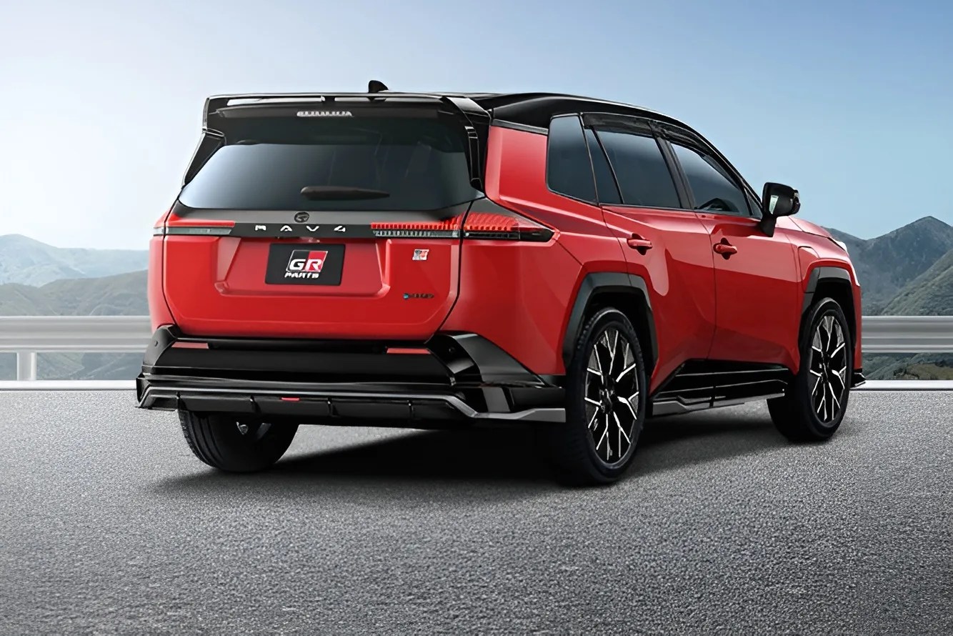 Red and black Toyota RAV4 GR Sport hybrid SUV rear view on a mountain road.