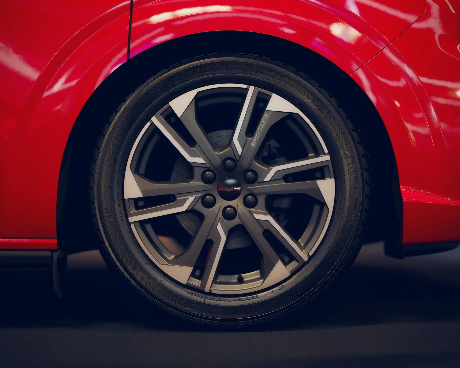 Close-up of a black and silver alloy wheel with "Sportline" branding on a red car.