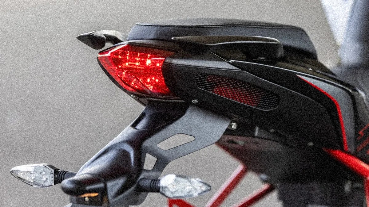 Close-up of a black motorcycle's rear section with red LED tail light and clear turn signals.