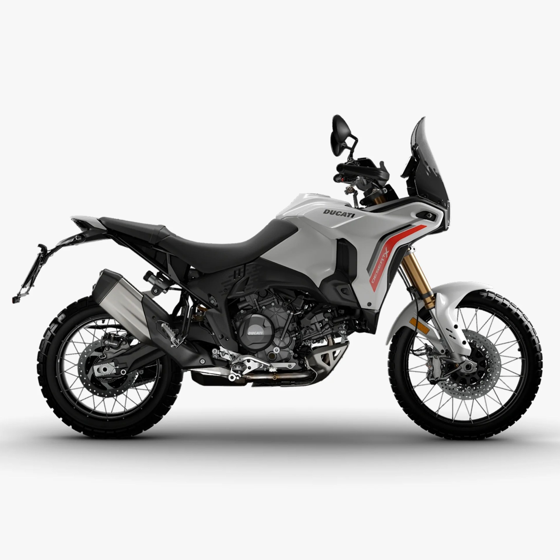 White Ducati DesertX adventure motorcycle with black seat, knobby tires, and tinted windshield on a white background.