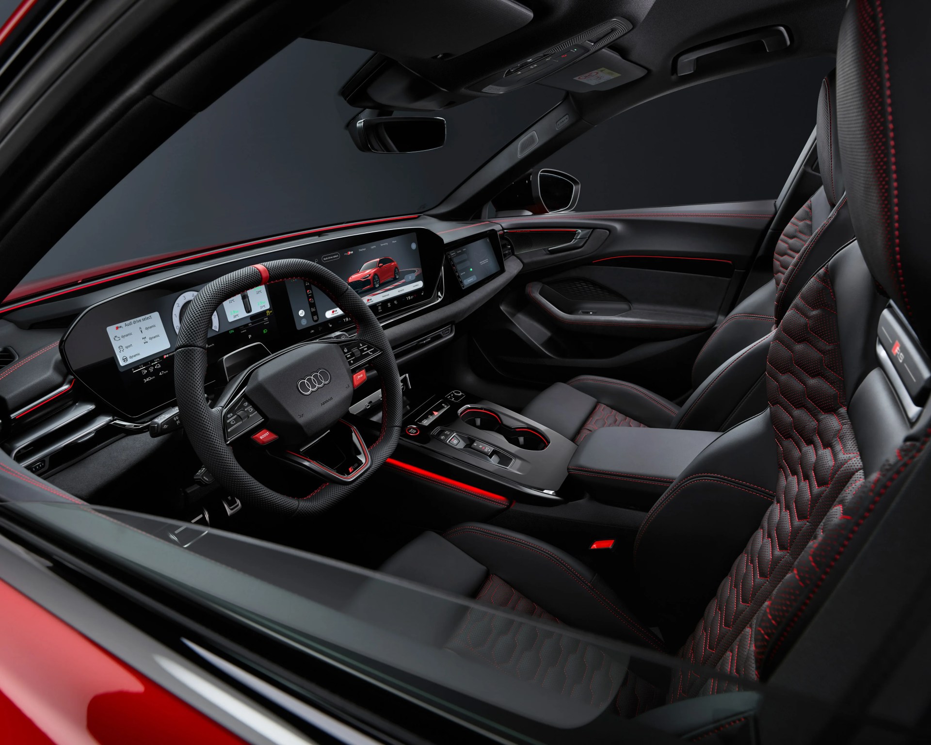 Black and red leather Audi RS car interior with digital dashboard and sporty steering wheel.