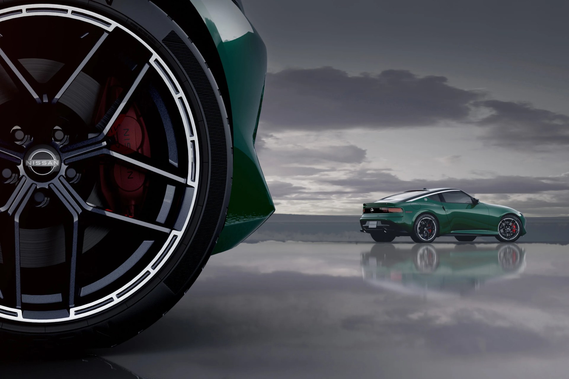 Close-up of a black and silver Nissan car wheel with red brake calipers, and a green Nissan sports car in the background on a reflective surface.