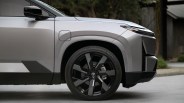 Close-up of the front left side of a silver Toyota vehicle showing a black alloy wheel and side mirror.