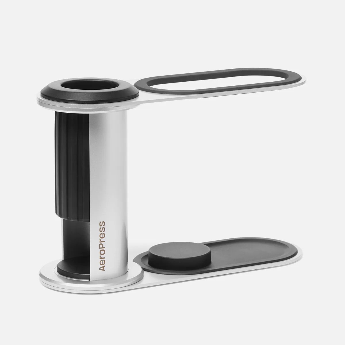 Silver and black AeroPress coffee maker with a black rubber seal and plunger on a white background.