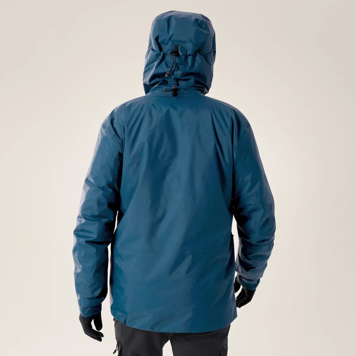 Blue waterproof jacket with adjustable hood worn by a person shown from the back.