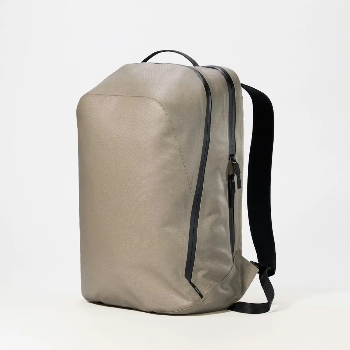 Beige rectangular backpack with black zippers and black shoulder straps on a white background.