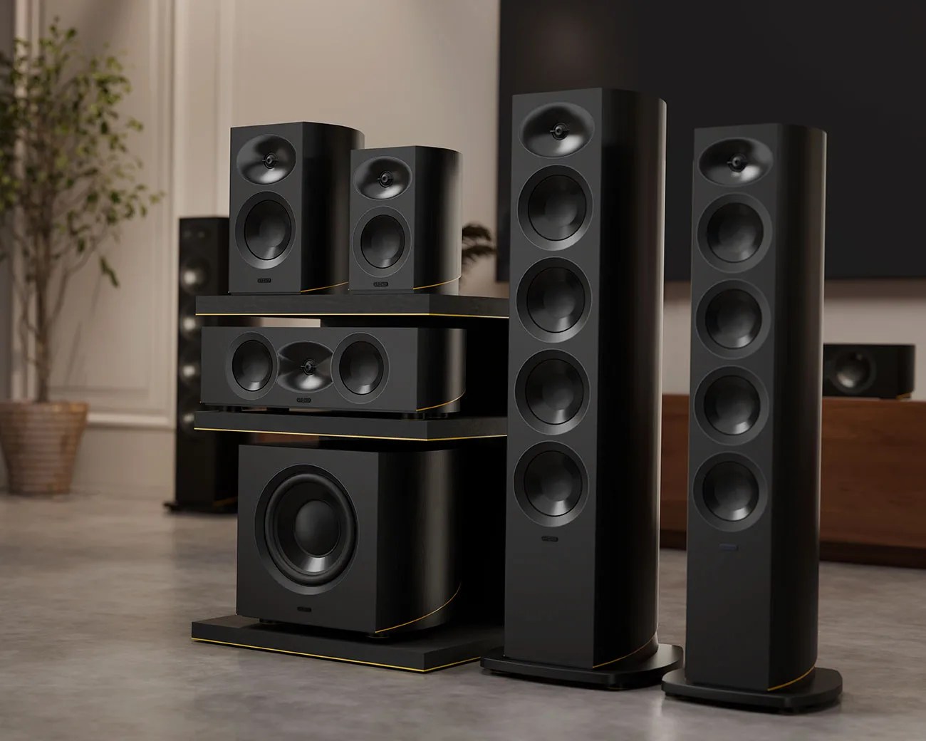 Set of black floor-standing and bookshelf speakers with gold trim in a modern living room.