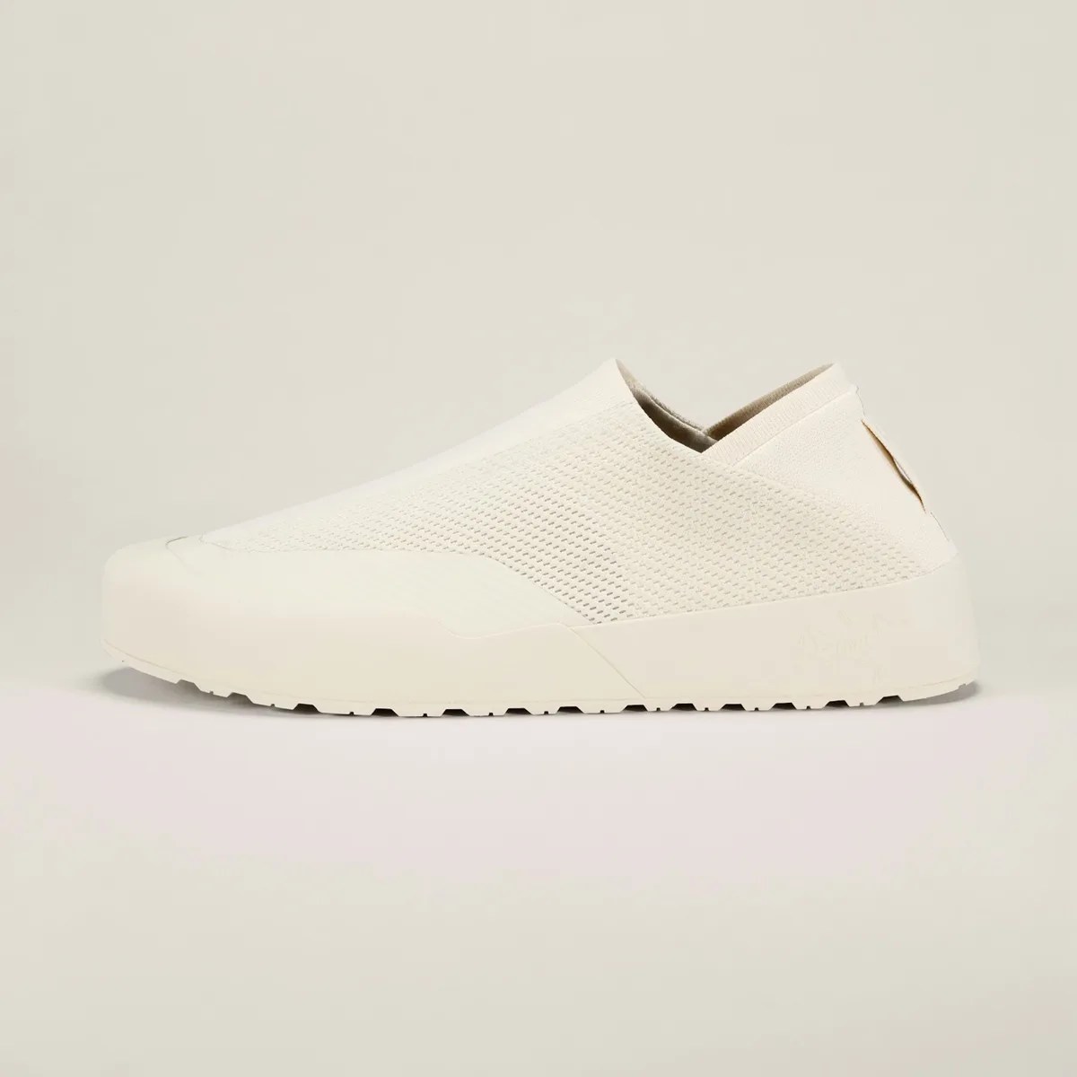 Off-white slip-on sneaker with textured knit upper and rubber sole on a neutral background.
