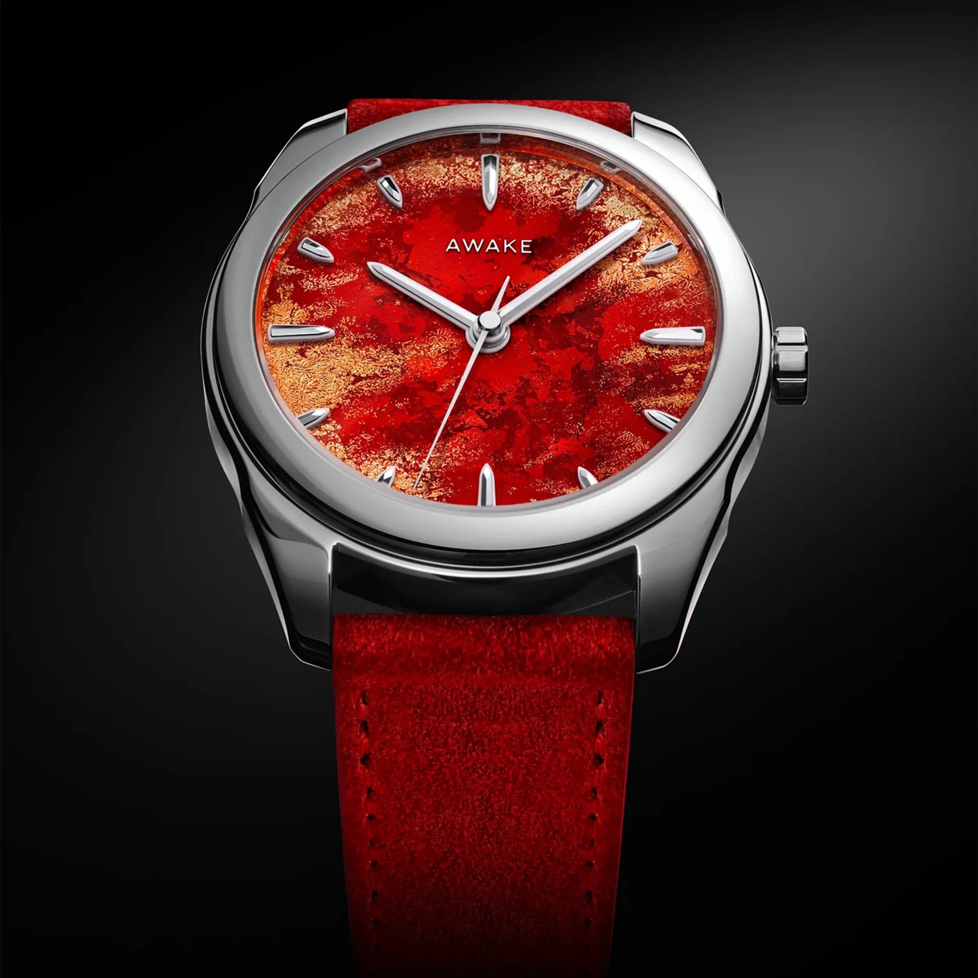 Silver watch with a textured red and gold dial and a red suede strap.