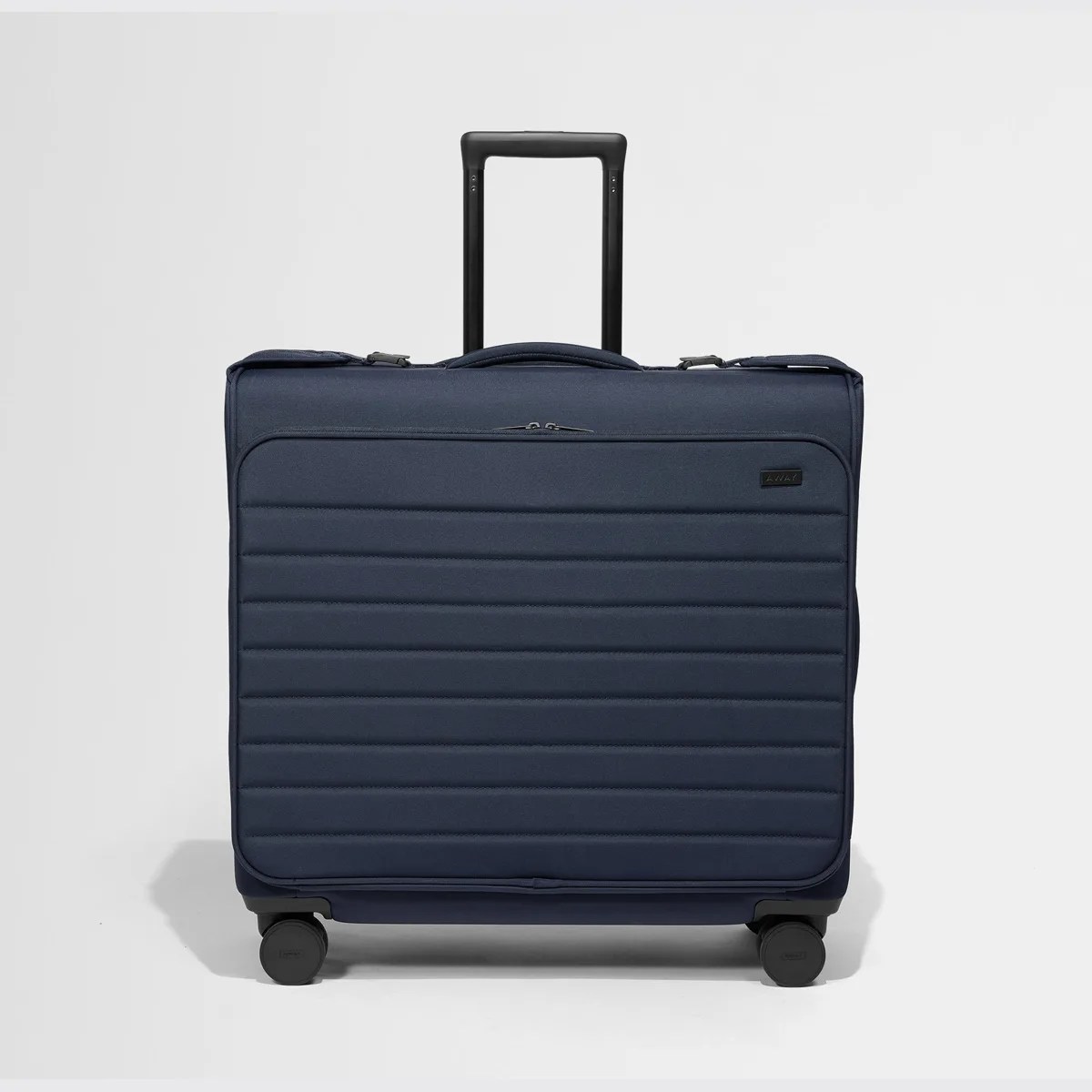 Navy blue soft-sided suitcase with horizontal quilting, black telescopic handle, and four black spinner wheels.