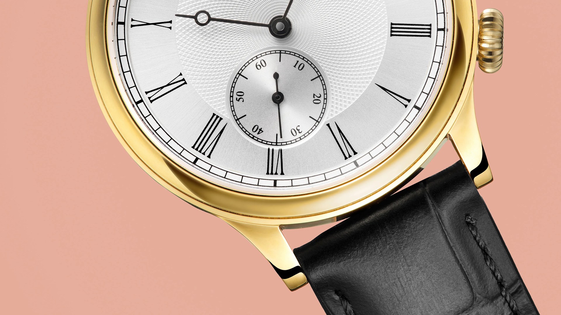 Close-up of a gold watch with a white dial, black Roman numerals, and a black leather strap on a peach background.