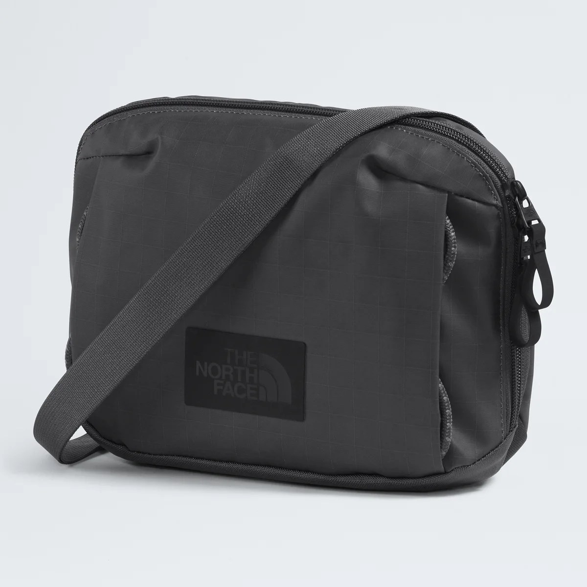 Black rectangular crossbody bag with adjustable strap and The North Face logo on front.