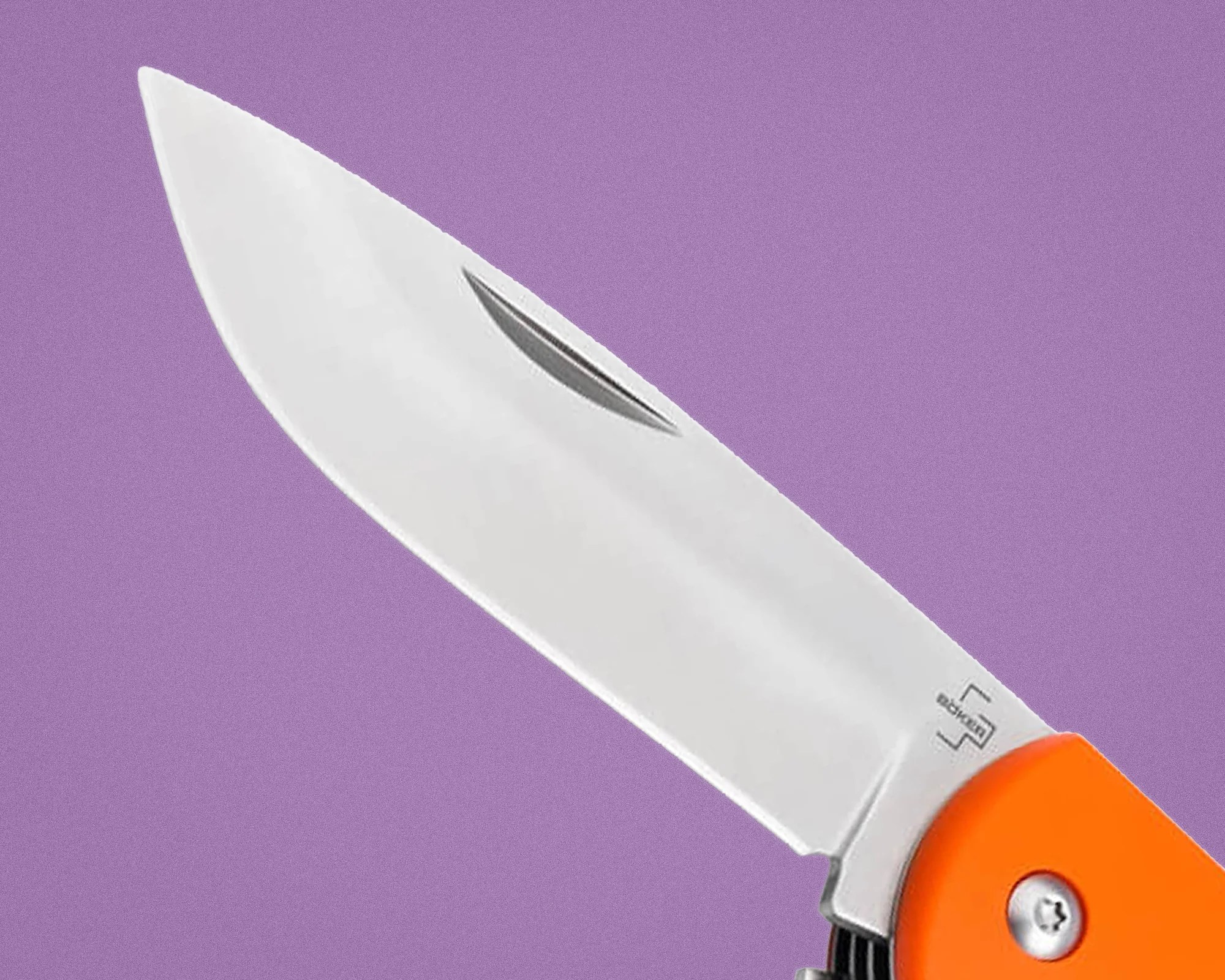 Close-up of a stainless steel folding knife blade with an orange handle against a purple background.