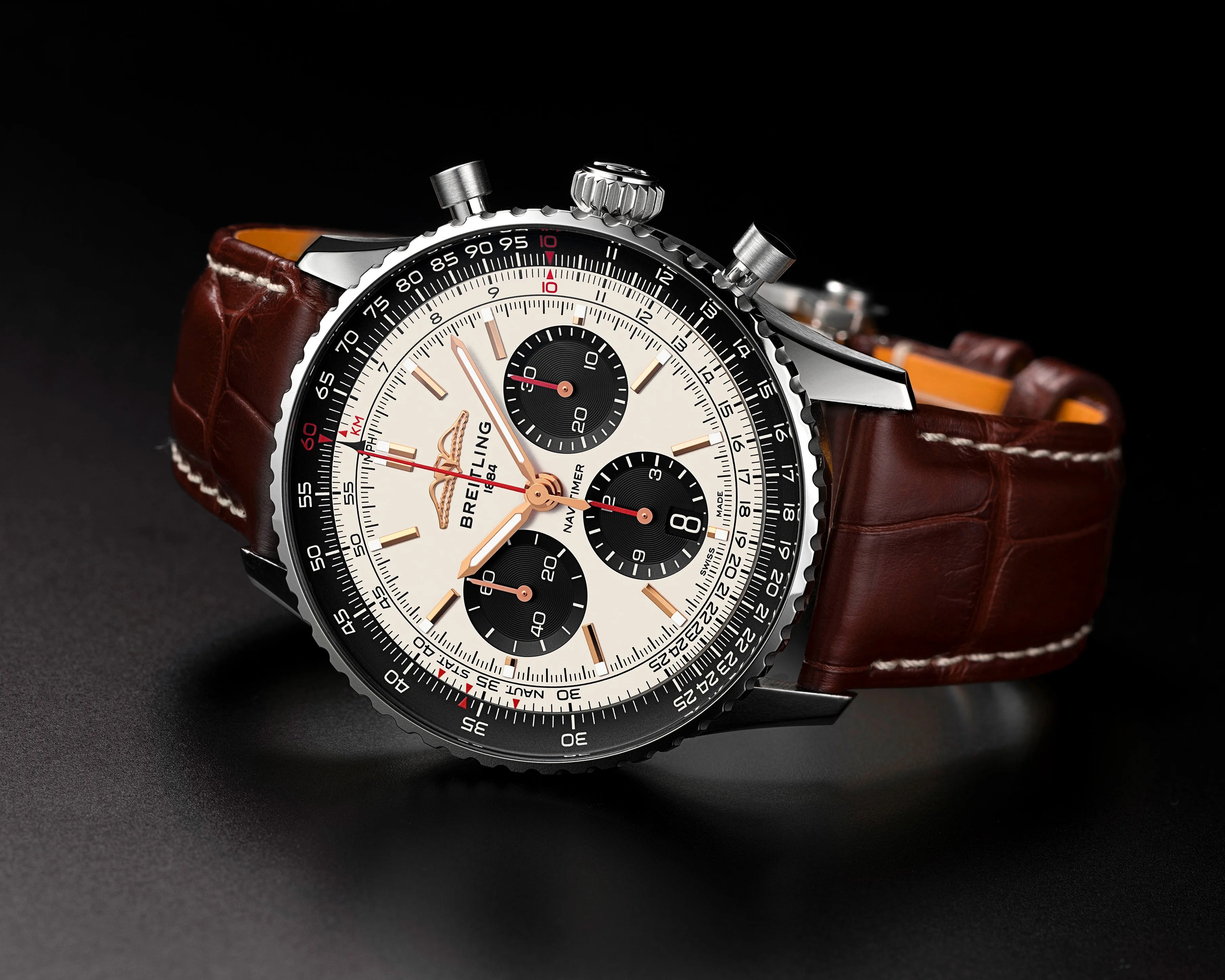 Breitling Navitimer watch with cream dial, black subdials, stainless steel case, and brown leather strap.