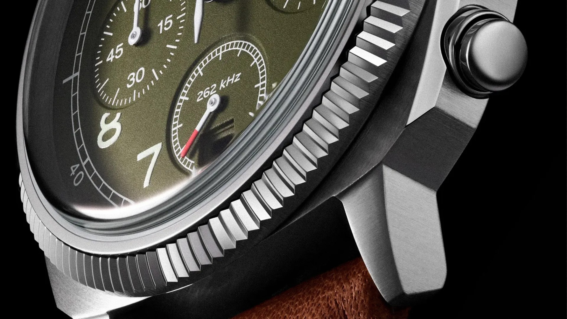 Close-up of a stainless steel watch case with a textured bezel, olive green dial, and brown leather strap.
