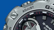 Close-up of a silver G-Shock Casio watch bezel and dial with "ADJUST" text and red and white markers.