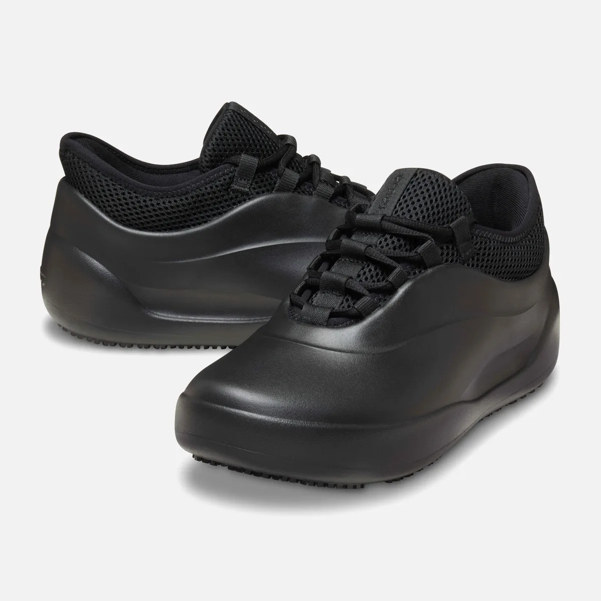 Pair of black slip-on sneakers with smooth rounded toe and mesh upper collar.