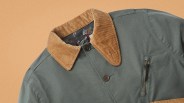 Green jacket with tan corduroy collar and a vertical zippered chest pocket.