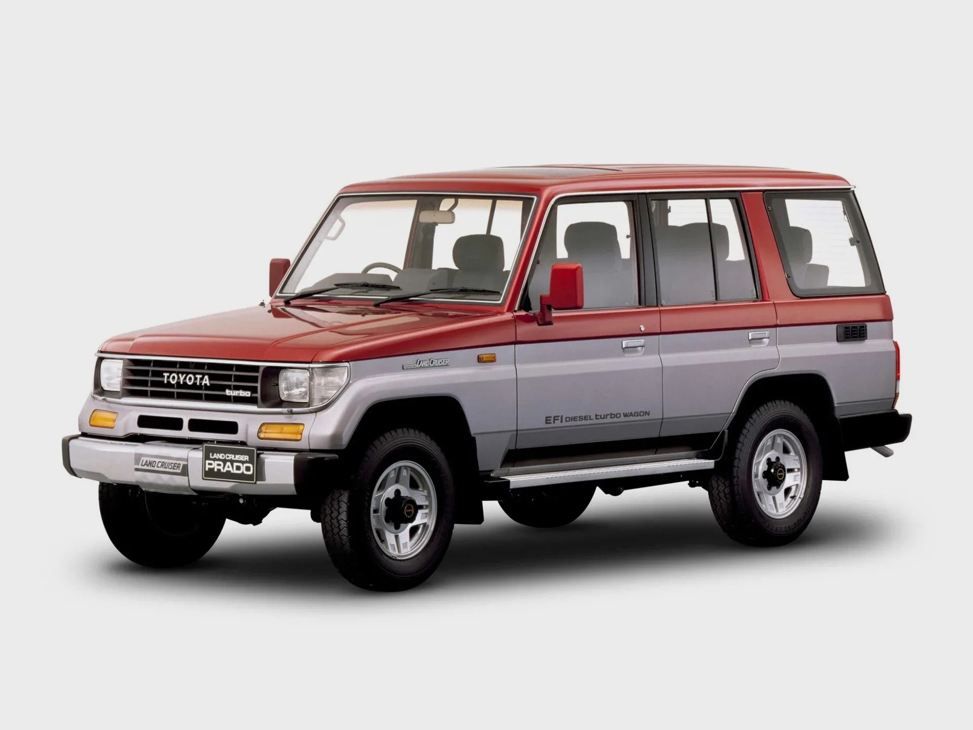 Two-tone red and silver Toyota Land Cruiser Prado SUV with boxy design and EFI diesel turbo wagon badge.
