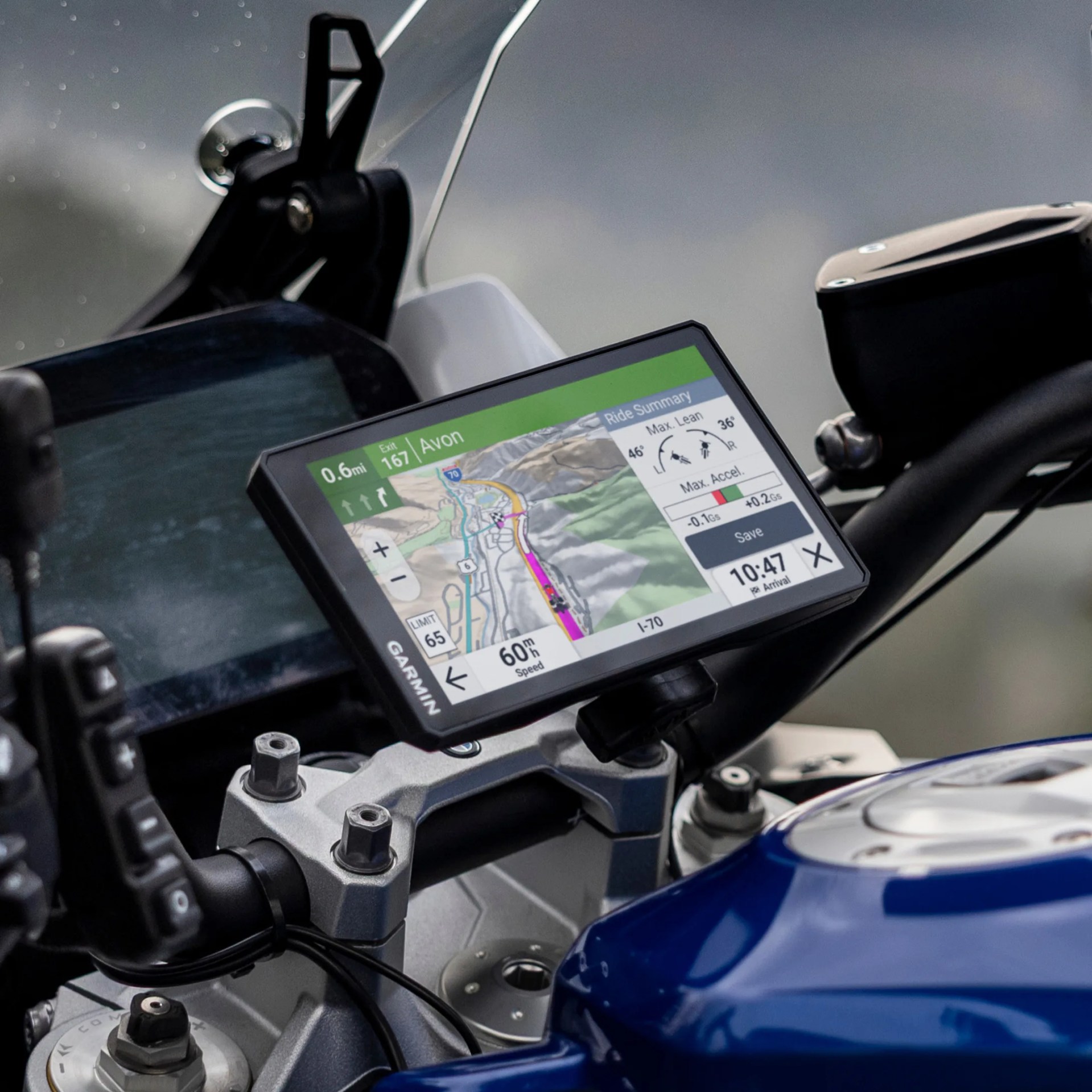 Garmin GPS navigation device mounted on a motorcycle handlebar showing a map and ride summary.