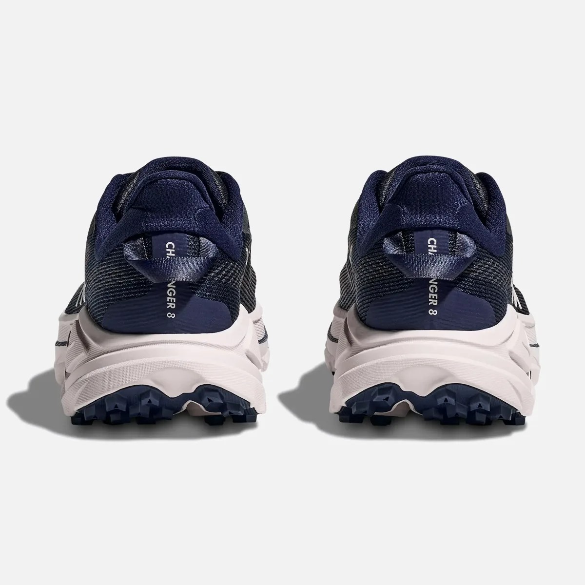 Pair of navy blue and white trail running shoes with rugged soles shown from the back.