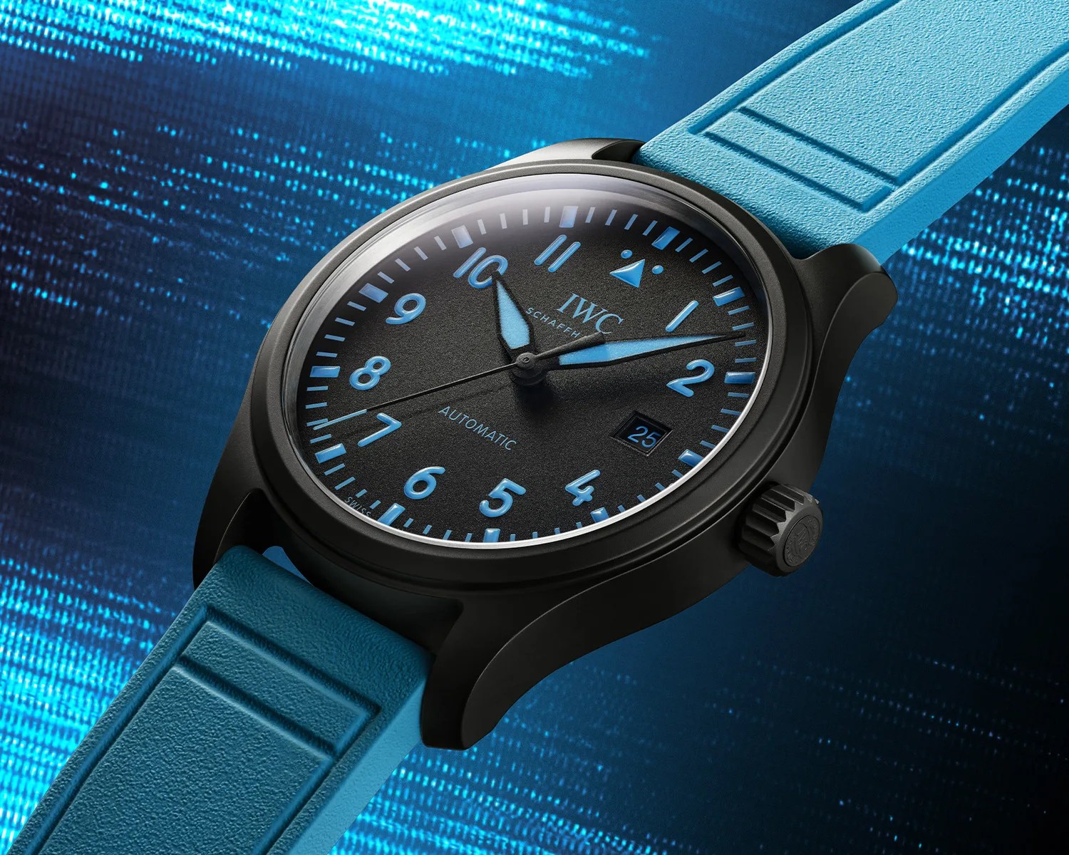 Black IWC wristwatch with blue numerals, blue hands, date window, and blue textured rubber strap on a blue digital background.