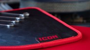 Black leather mat with red trim and a black tag labeled "ICON" in red letters.