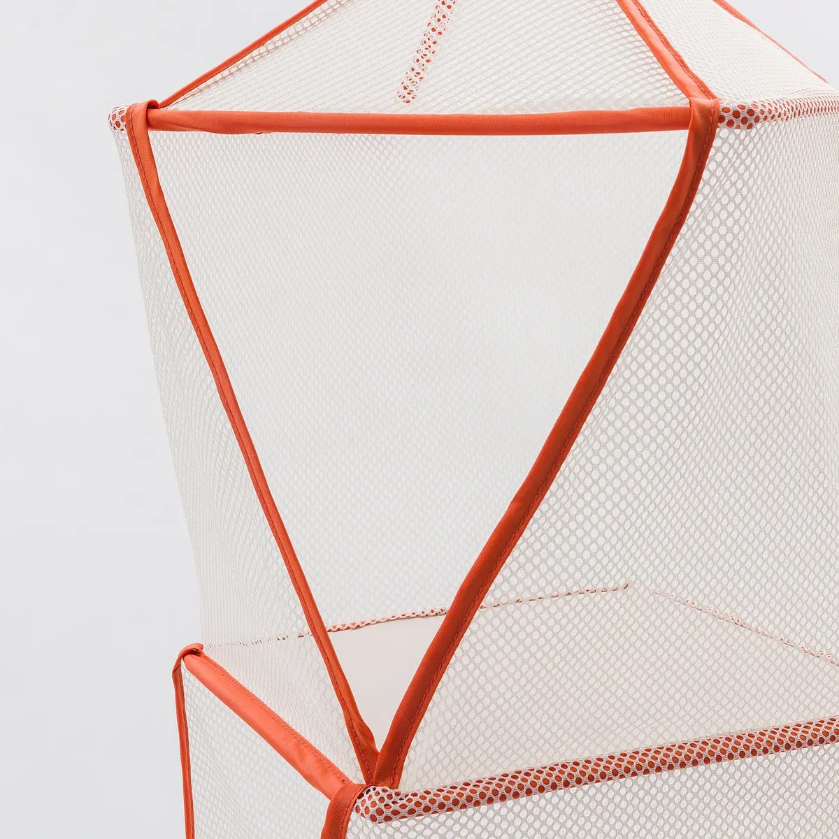 White mesh laundry hamper with orange trim and a triangular opening.