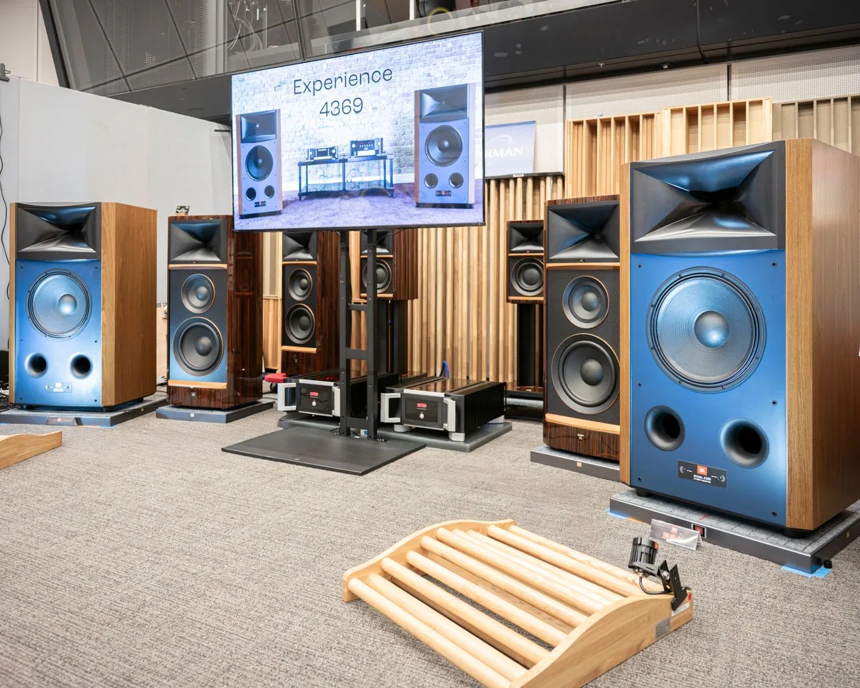 Pair of large vintage JBL 4369 speakers with blue front panels and wood cabinets in a listening room.
