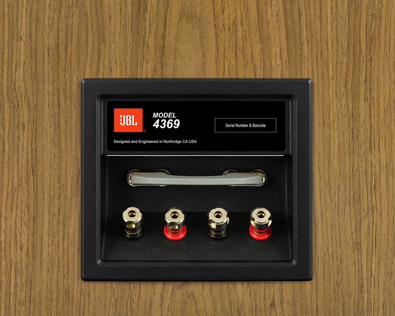 Black rectangular speaker terminal panel with gold and red binding posts and JBL Model 4369 label on wood grain surface.
