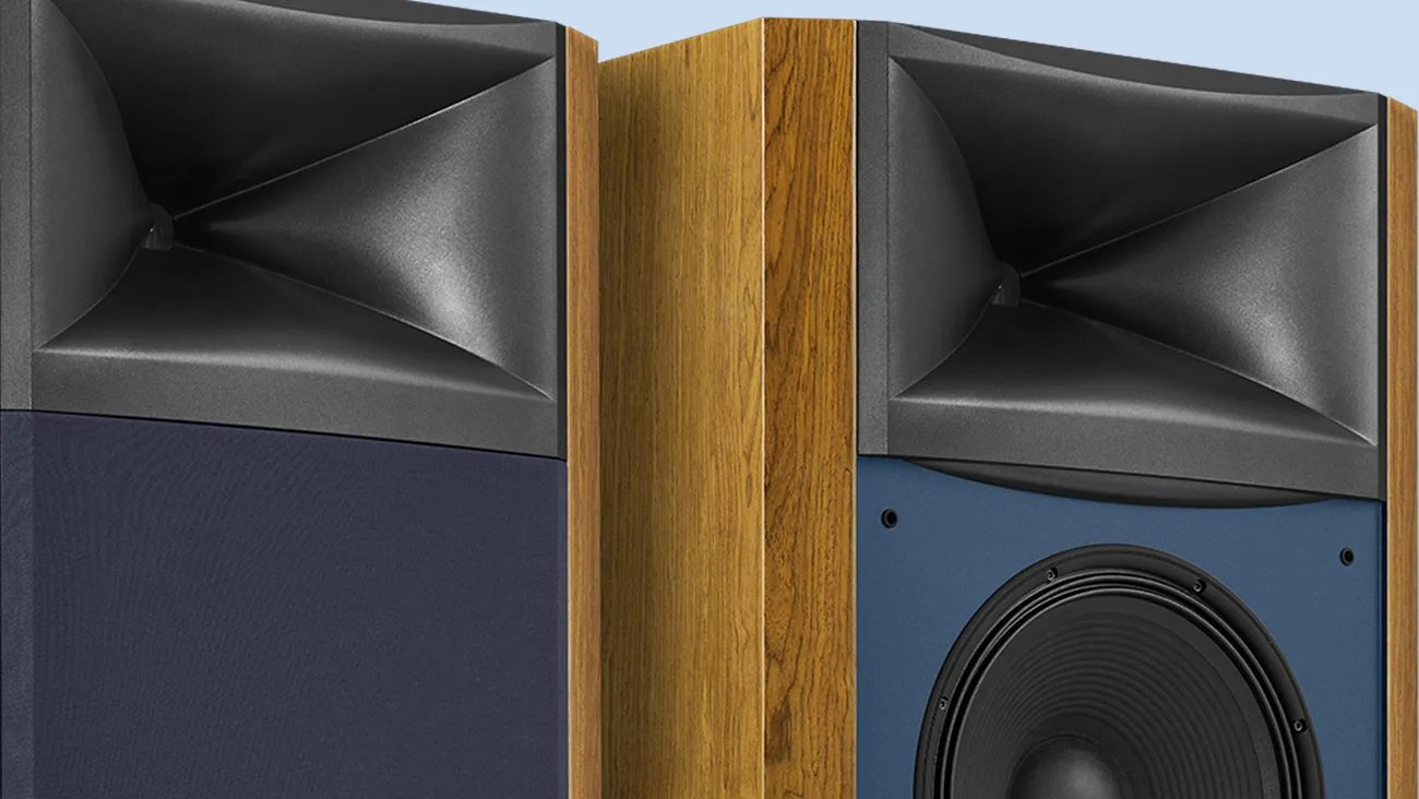 Pair of wooden floor-standing speakers with black horn tweeters and blue fabric covers, one partially removed.