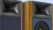 Pair of wooden floor-standing speakers with black horn tweeters and blue fabric covers, one partially removed.