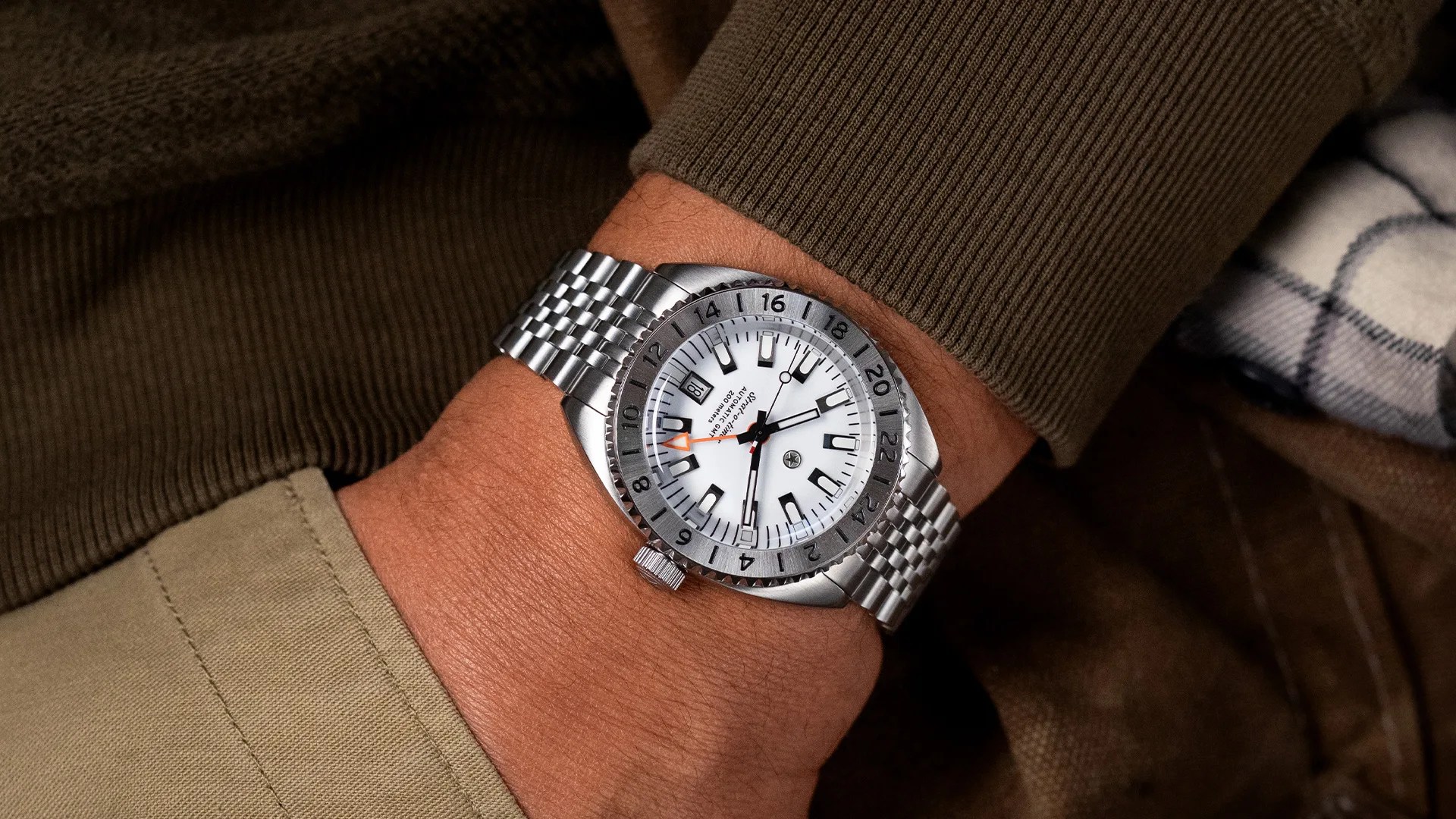 Silver stainless steel wristwatch with white dial and black hour markers worn on a wrist.