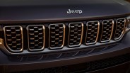 Close-up of a black Jeep front grille with seven vertical slots and the Jeep logo above.