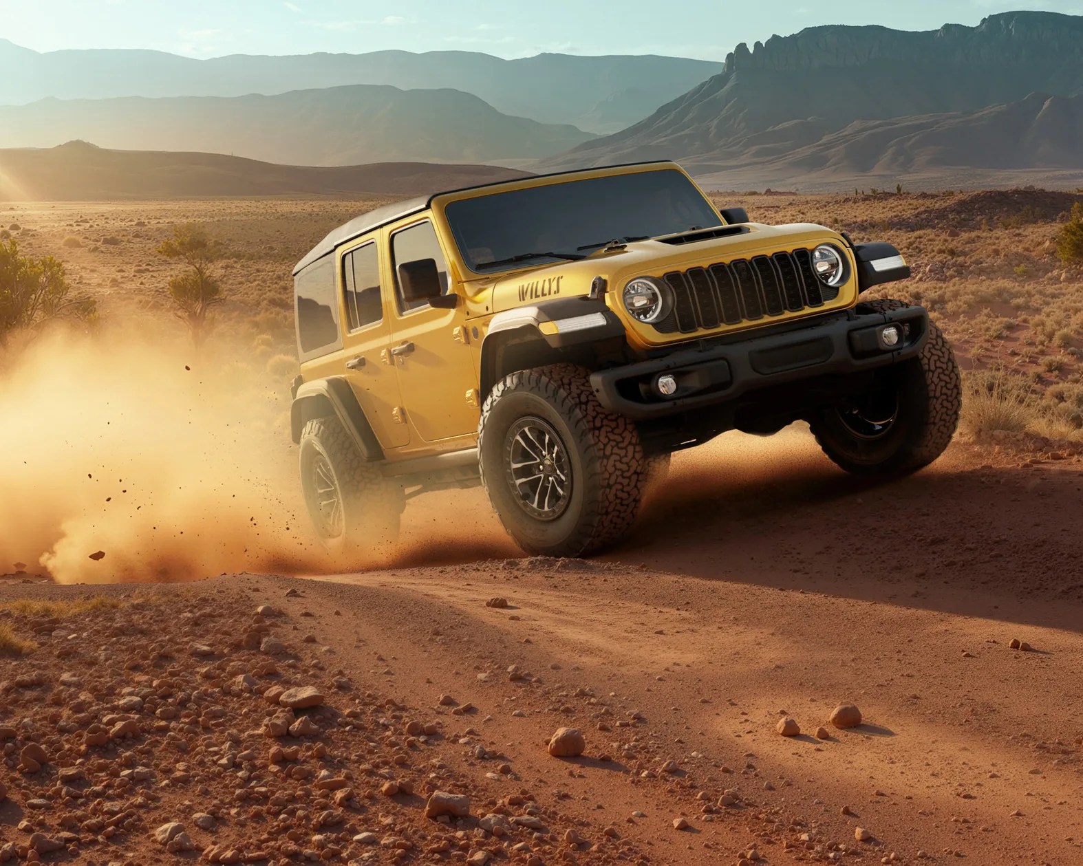 Yellow Jeep Wrangler Willys driving on a dusty off-road trail with mountains in the background.