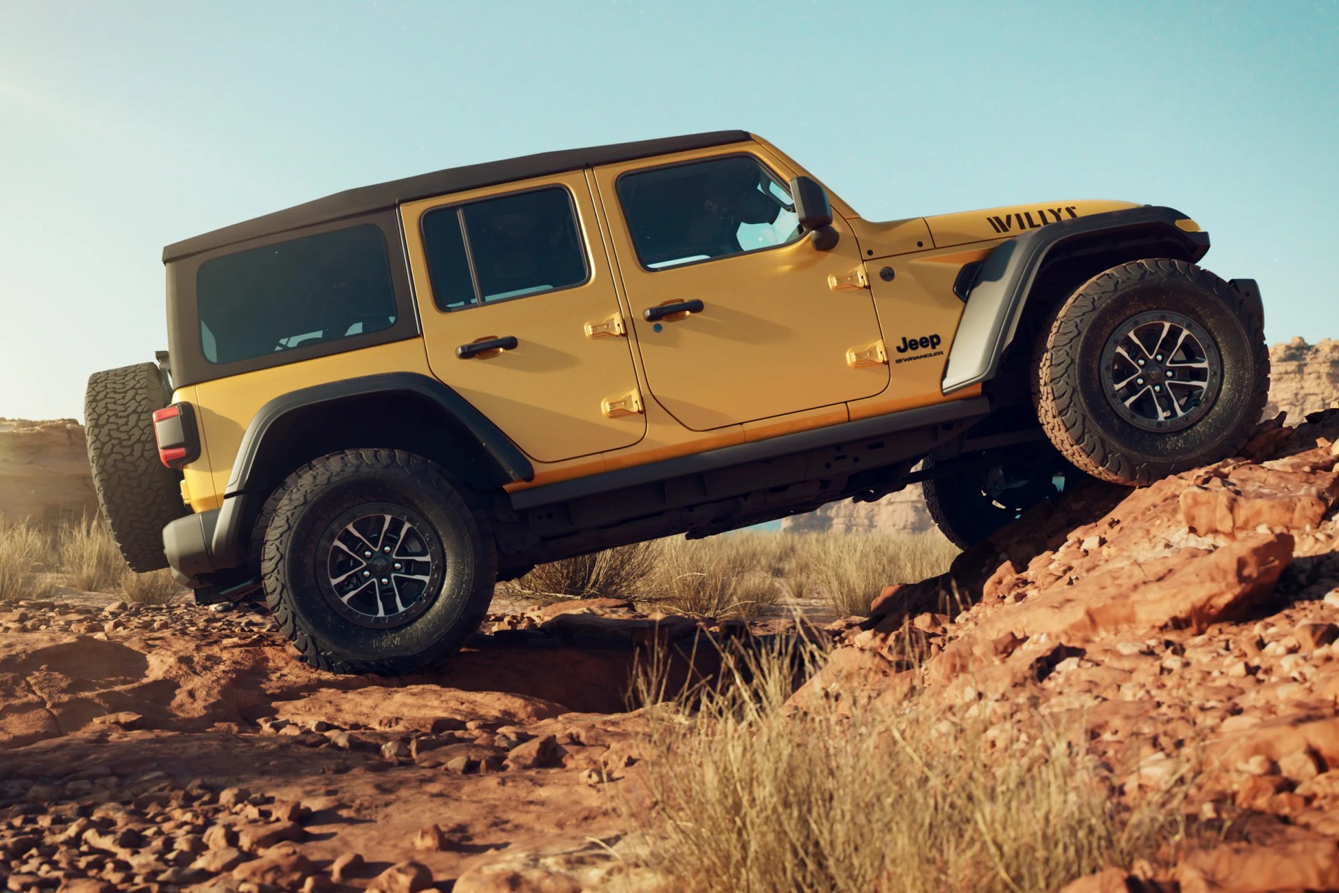 Yellow Jeep Wrangler 4-door with black roof climbing rocky terrain in a desert setting.
