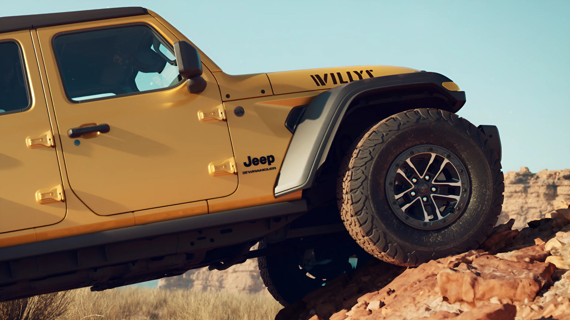 Yellow Jeep Wrangler Willys climbing rocky terrain with visible rugged tires and black fender flares.