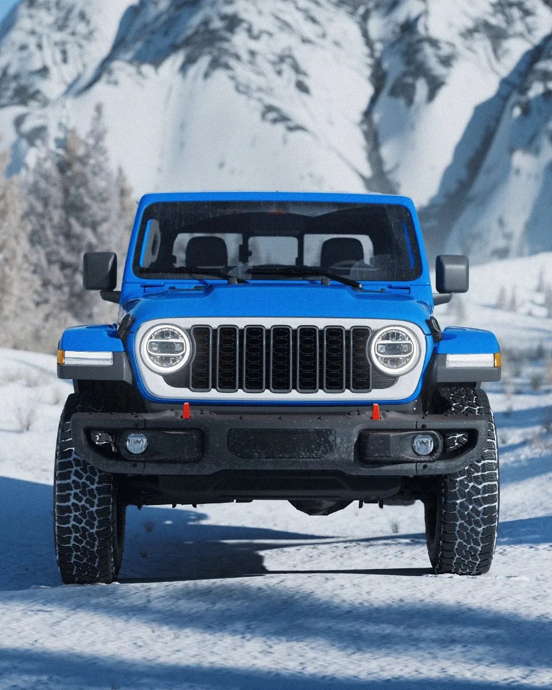 Blue off-road SUV with round headlights and rugged tires on a snowy mountain road.