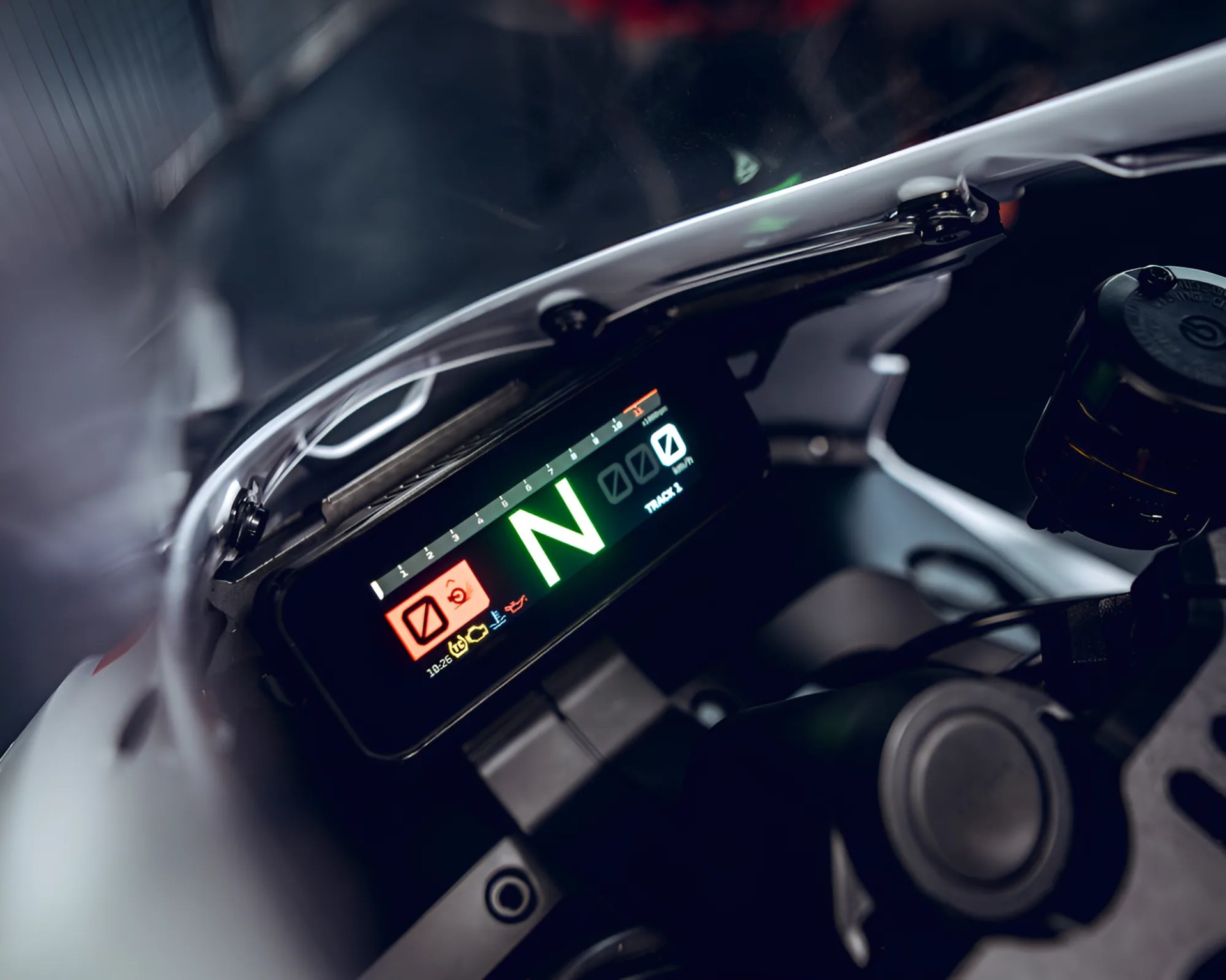 Close-up of a motorcycle digital dashboard showing neutral gear and various warning indicators.