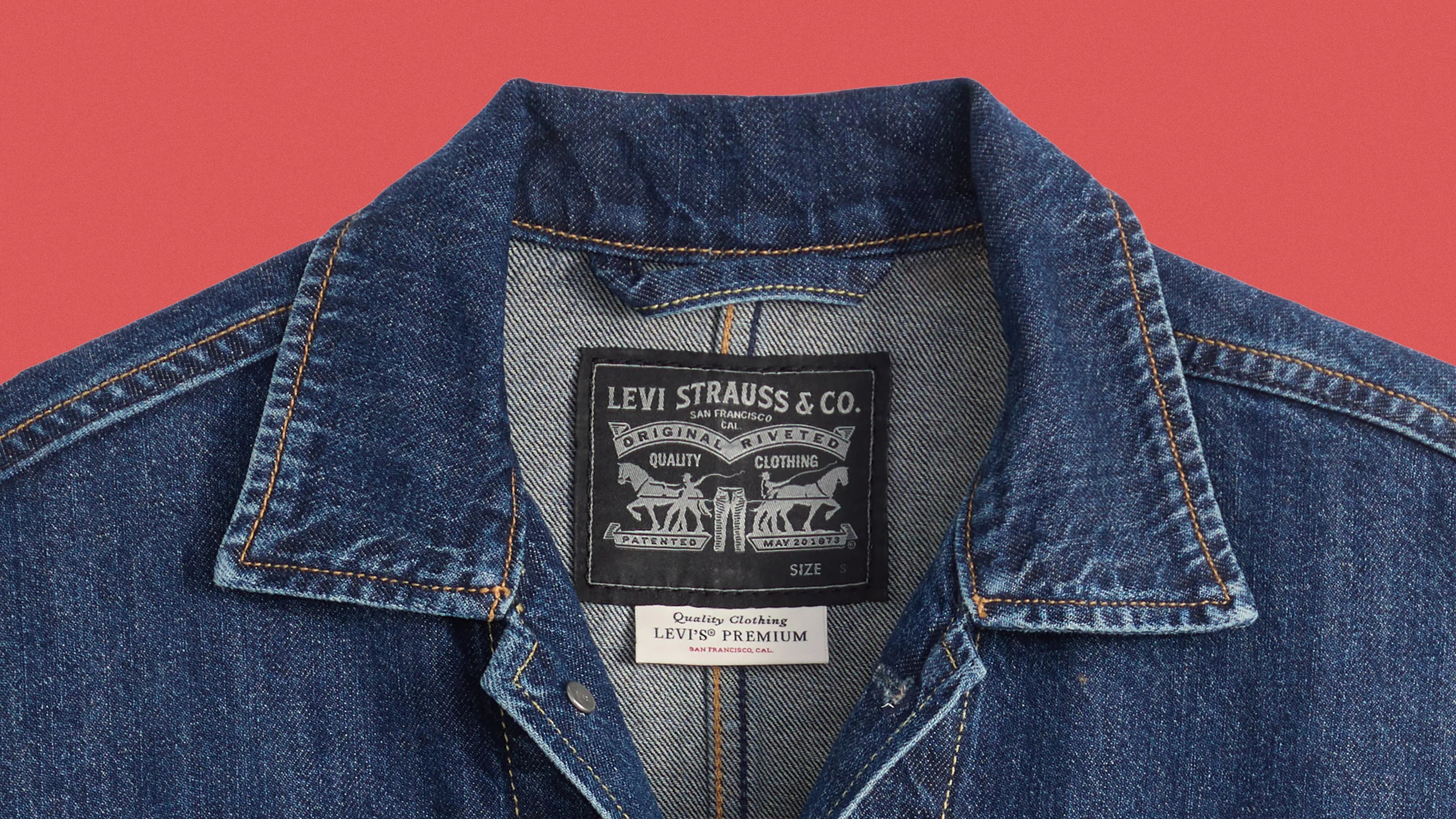 Dark blue denim jacket collar with Levi Strauss & Co. label and Levi's Premium tag on a red background.