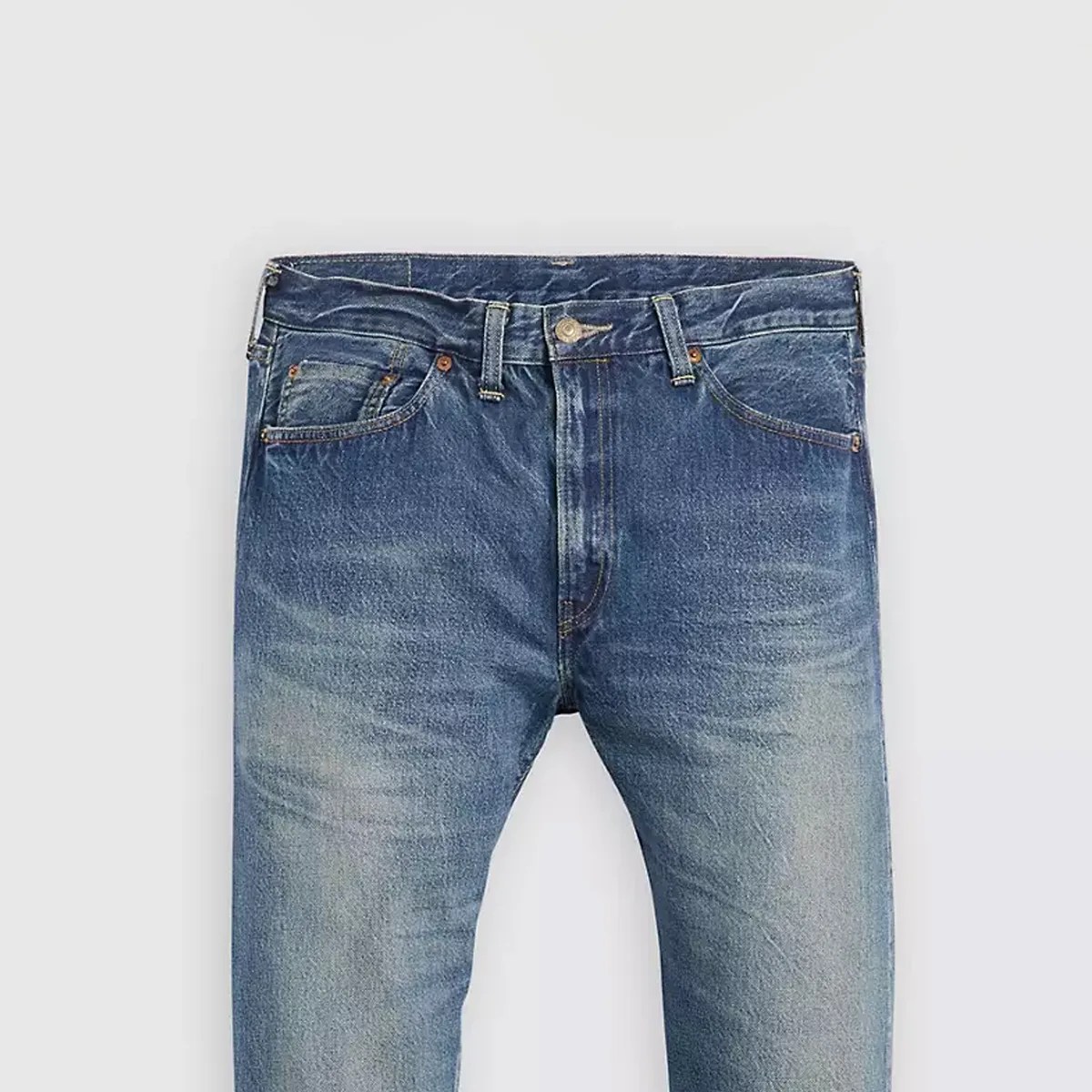 Blue faded denim jeans with front pockets and belt loops on a light background.