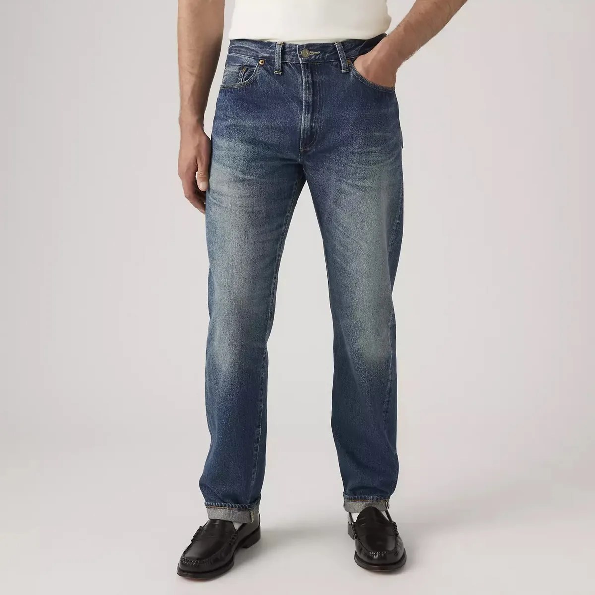 Blue faded straight-leg jeans worn with black leather loafers and a white top.