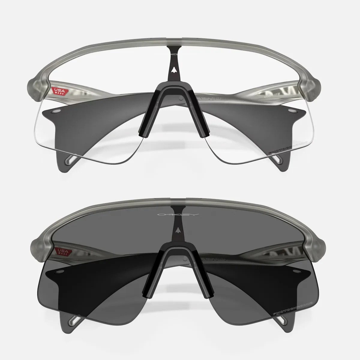 Two pairs of Oakley sports sunglasses with translucent gray frames, one with clear lenses and one with dark tinted lenses.