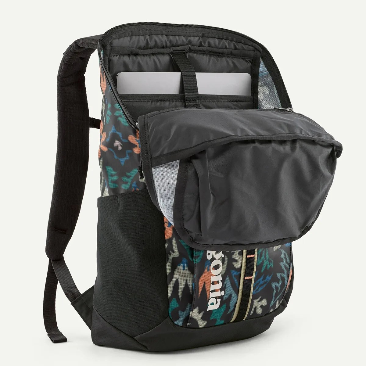 Colorful patterned Patagonia backpack with black padded straps and an open laptop compartment showing a laptop inside.